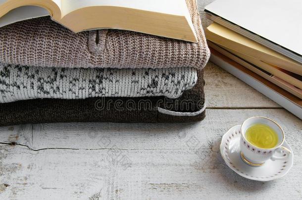 舒适的暖和的愈合长<strong>大衣毛衣</strong>,书和杯子关于茶水向木制的