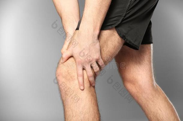 年幼的男人受苦从痛苦采用腿