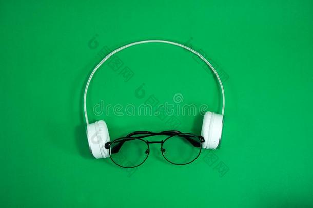 眼镜和白色的耳机向一绿色的b一ckground.