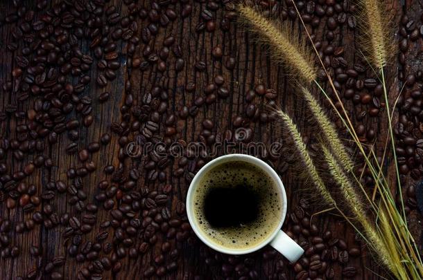 咖啡<strong>豆</strong>杯子和干的干燥的草<strong>花</strong>和咖啡<strong>豆豆</strong>向木制的帐单