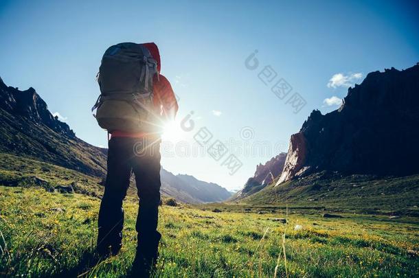 女人远足者和背包徒步旅行向高的高度山