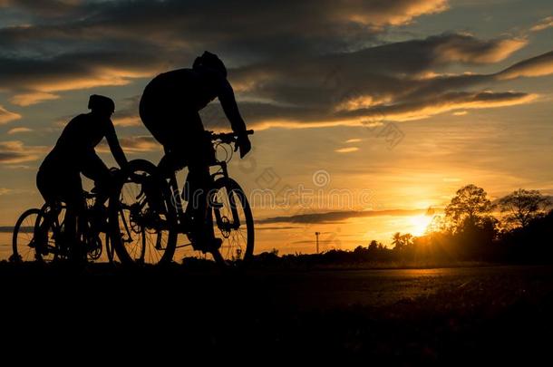 指已提到的人人乘自行车在日落和桔子-<strong>蓝</strong>色天<strong>背景</strong>.