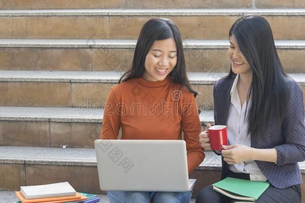 商业女人和青少年建议和使用便携式电脑在户外的楼梯