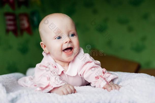 小的婴儿女孩.蓝色眼睛.微笑的.粉红色的衣服.
