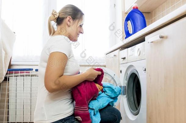 美丽的白肤金发碧眼女人家庭主妇装货洗涤机器