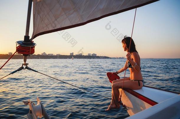年幼的漂亮的微笑的女人在奢侈快艇采用海,look采用g福娃