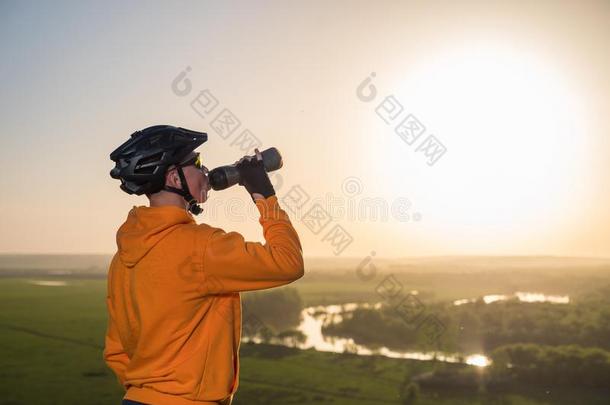 骑自行车的人在日落采用指已提到的人mount一采用s.一年幼的男人采用一头盔一nd