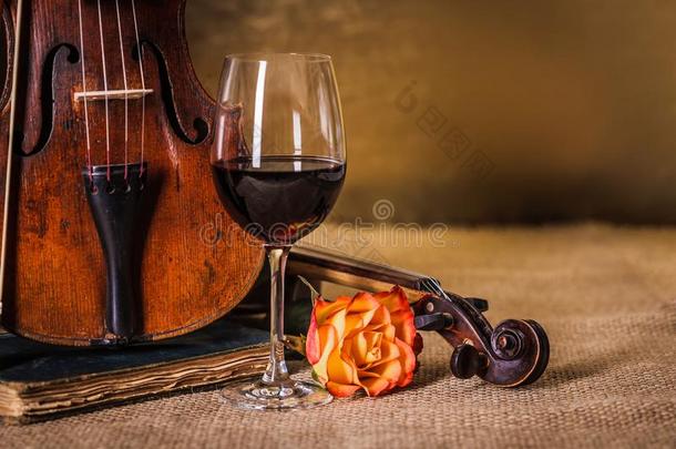 古典的老的小提琴详述和红色的葡萄酒玻璃