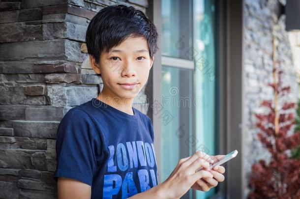 亚洲人十几岁的男孩使用智能手机,通讯科技.