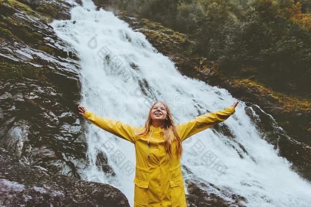 幸福的微笑的女人旅行者凸起的手享有瀑布