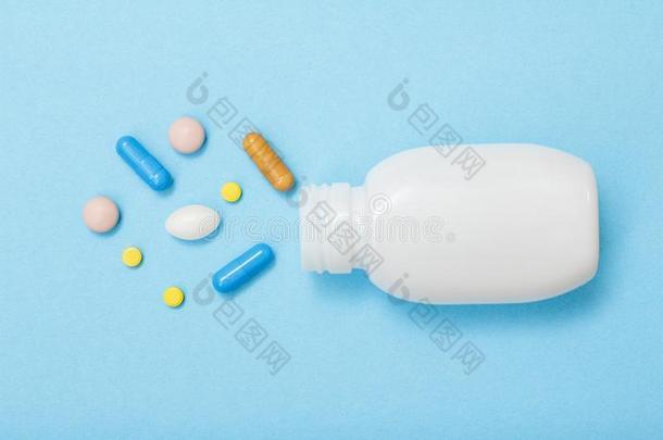 白色的瓶子和不同的药丸和胶囊向蓝色后座