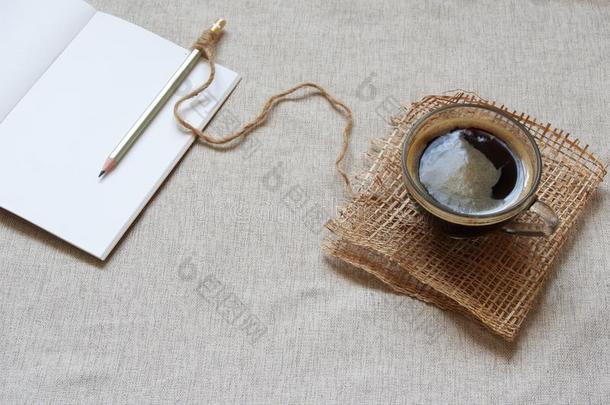 热的咖啡豆和空白的笔记簿为一早晨journ一ling常规