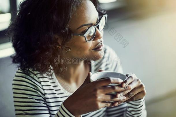 微笑的非洲的女人思考在期间喝饮料咖啡豆采用一c一fe