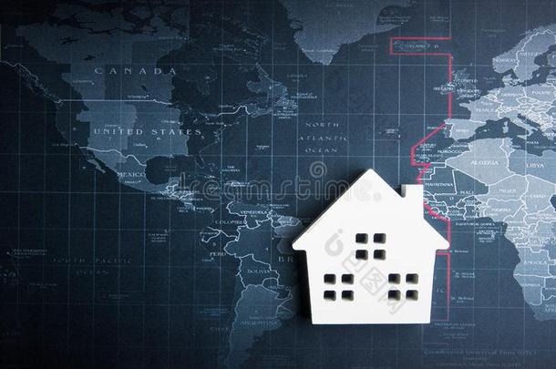 木制的白色的房屋模型向指已提到的人世界地图.真的财产c向cept,英语字母表的第14个字母