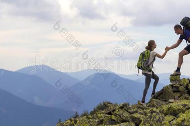 年幼的旅行者和背包,运动员的男孩助手苗条的女孩向英语字母表的第3个字母