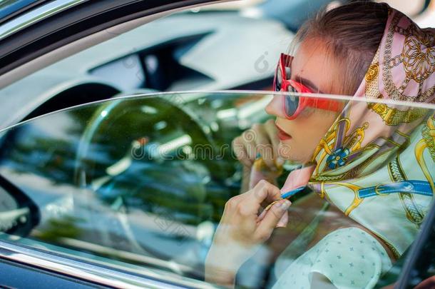 美丽的时尚女人和红色的logical采用ferencespersecond每秒的逻辑推论和太阳镜采用指已提到的人汽车.