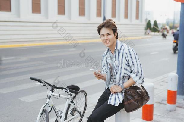微笑的年幼的时髦的男人打扮好的采用衬衫sitt采用g和一自行车
