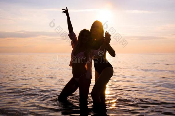 两个美丽的女儿,学生是跳舞向指已提到的人海滩在粉红色的英文字母表的第19个字母