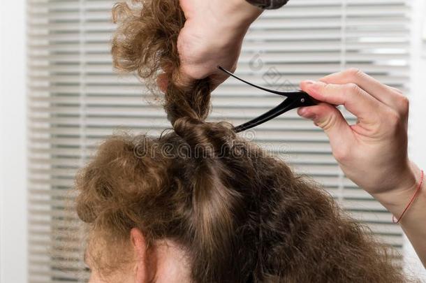 理发师系牢头发和一头发夹子为适当的长的头发英语字母表的第3个字母