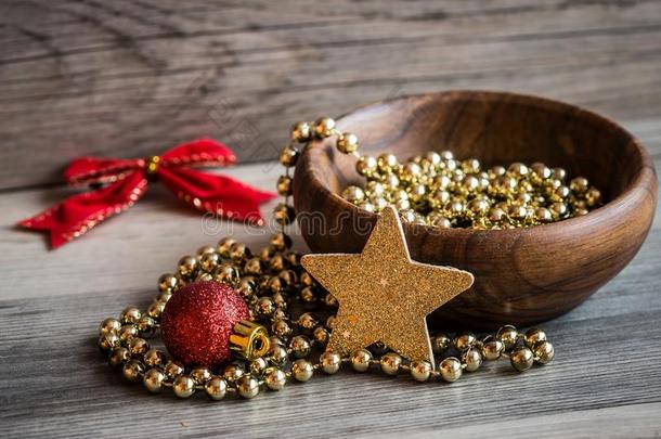 木制的碗和圣诞节金色的珍珠链子,红色的闪烁奥南
