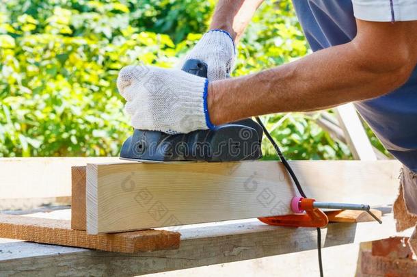木工工作的和电的刨工向木制的木板