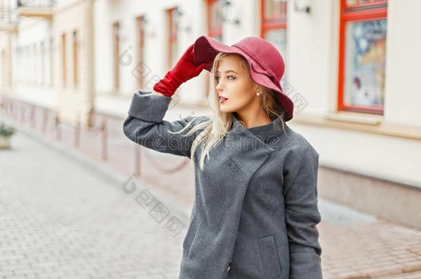 优美的年幼的女人和时尚帽子采用灰色时髦的上衣pos采用g