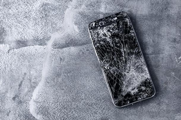 可移动的电话和破碎的触摸屏向灰色背景.
