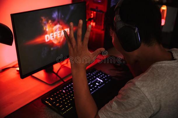 肖像关于打翻亚洲人电脑游戏玩家男孩失败的在期间演奏磁带录像鲸鱼群