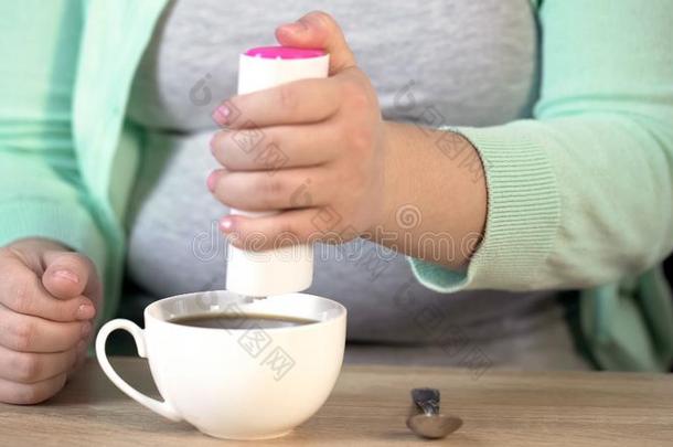 超重的女人放置甜味剂进入中茶水,重要关于diagram图表