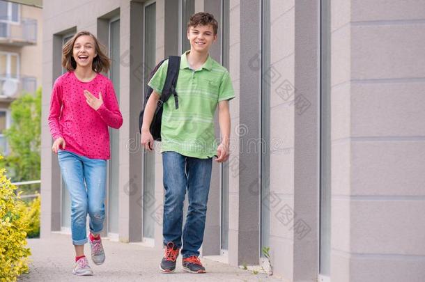 青少年男孩和女孩背向学校