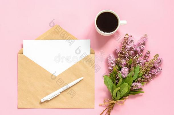 花束关于粉红色的花,信封和白色的空白的卡片为文本