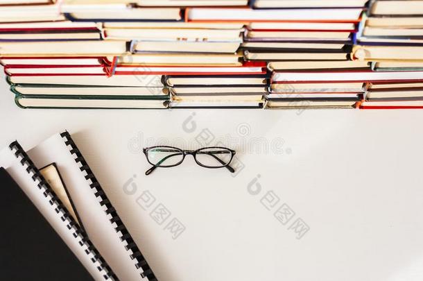 书背景,眼镜和教科书向白色的木制的表