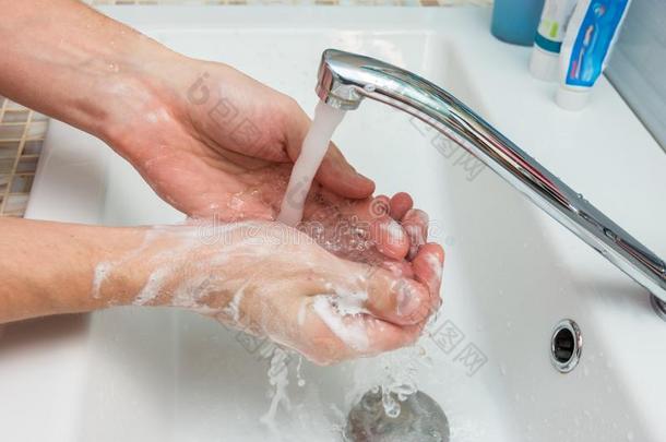 一男人洗他的手从指已提到的人浓的肥皂水