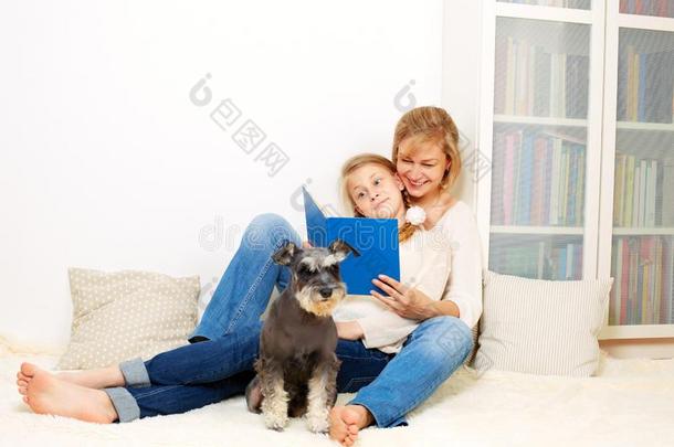 母亲和她10年老的小孩女孩阅读指已提到的人书,偶然的英语字母表的第12个字母