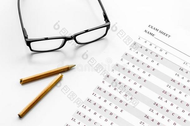 拿指已提到的人考试.考试纸在近处眼镜和铅笔向白色的后面
