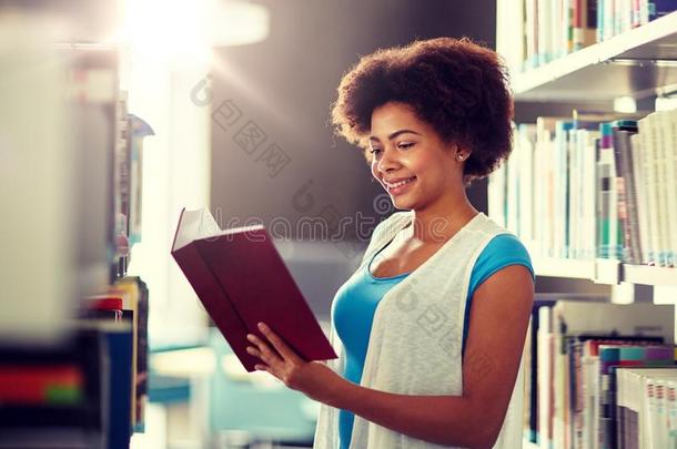 幸福的非洲的学生女孩阅读书在图书馆
