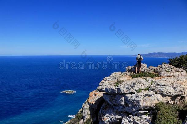 背看法关于自由男人台向岩石悬崖有样子的在蓝色海