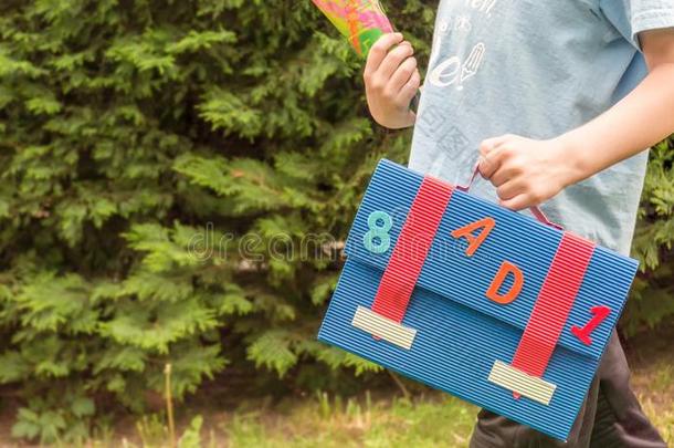 小孩支撑食糖袋和书包向一学校教育p一rty