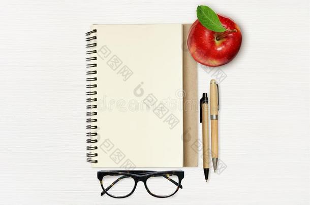 空的笔记簿页,红色的苹果树叶,笔和眼镜