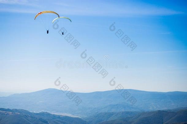 进行滑翔伞运动轮廓飞行的越过山山峰,美丽的微量