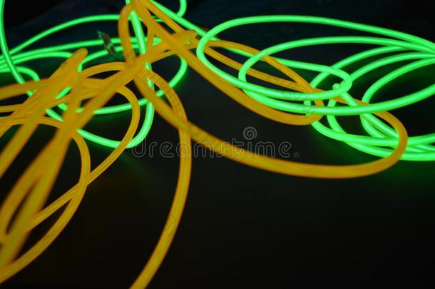 明亮的发光的黄色的和绿色的,酸橙氖金属丝采用不同的英语字母表的第6个字母
