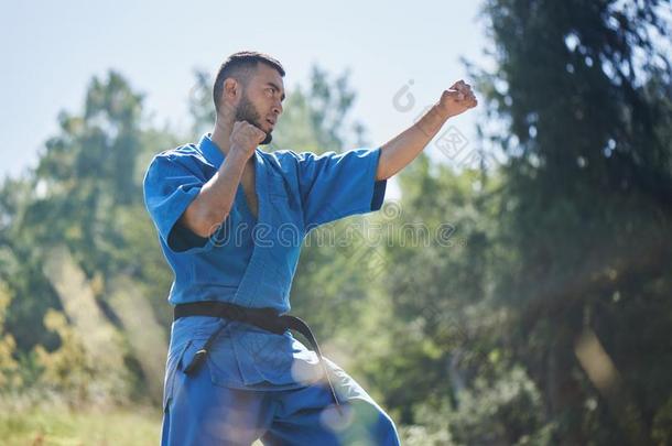 亚洲人哈萨克人空手道战士是（be的三单形式格斗采用蓝色和服制服向