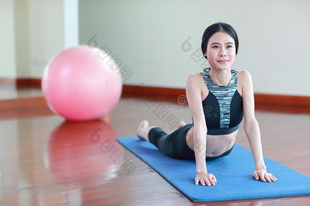 像运动家的女孩开业的瑜伽和伸采用健身房