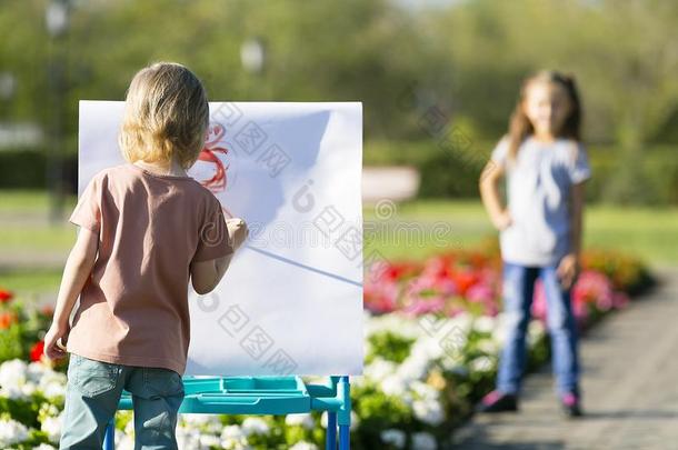 小的男孩绘画他的姐妹同样地一模型