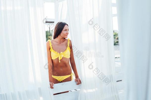 鞣酸处理的女人采用黄色的游泳衣白色的<strong>帐</strong>篷
