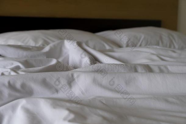 摺皱的<strong>凌</strong>乱的白色的毛毯不整洁的,使消失床纸后的瓦基