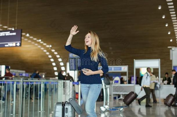 学生起立在机场过道和智能手机,旅行小皮包和拉埃