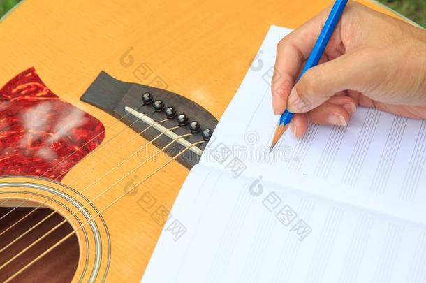 作曲家写笔记关于歌曲和使用听觉的吉他
