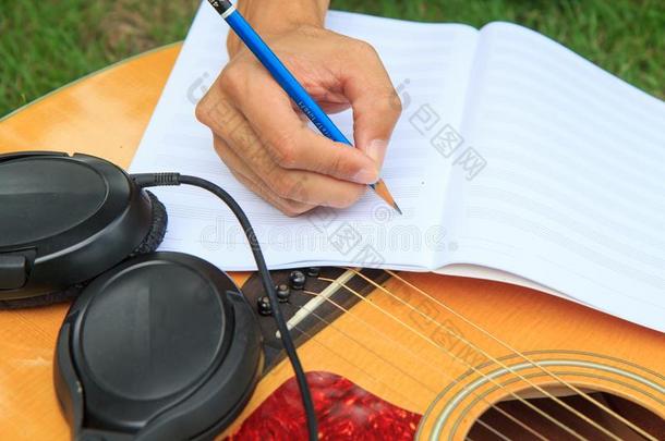 作曲家写笔记关于歌曲和使用听觉的吉他