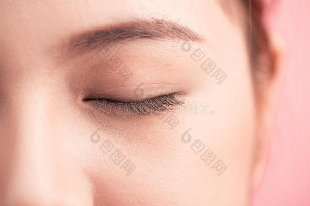 美丽的亚洲人女人眼睛和长的眼睛lashes隔离的向粉红色的英语字母表的第2个字母